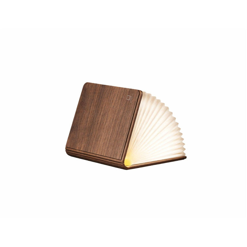 Wooden book-shaped lamp with a warm glow on a white background