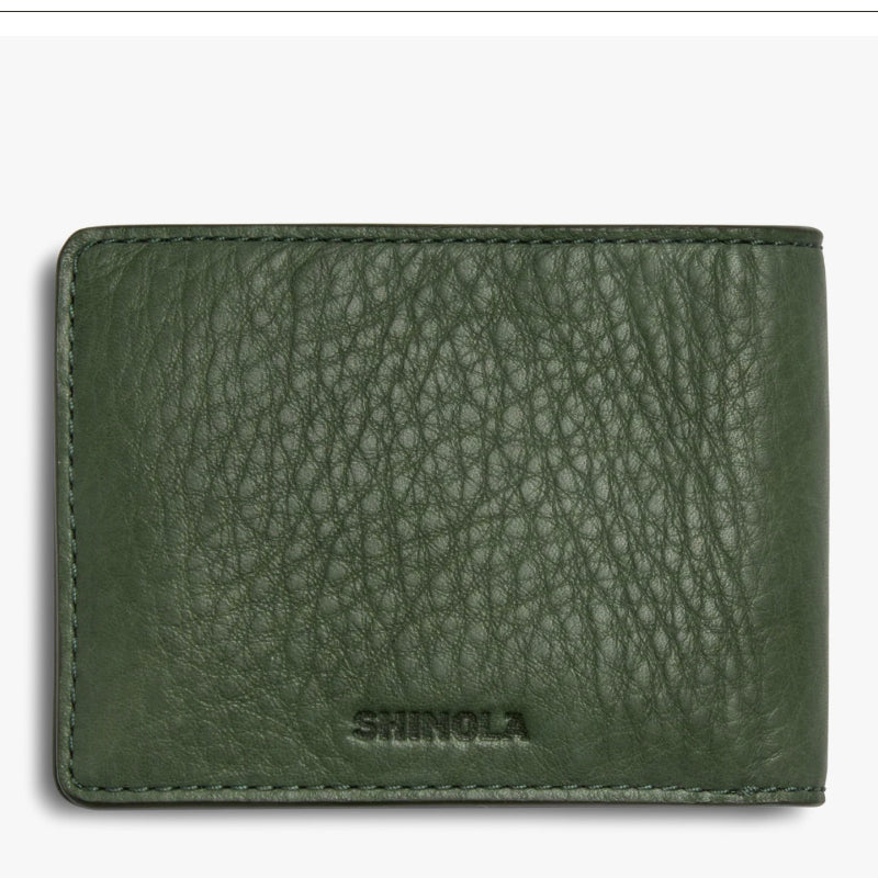 Green leather wallet with 'Shinola' branding on a white background