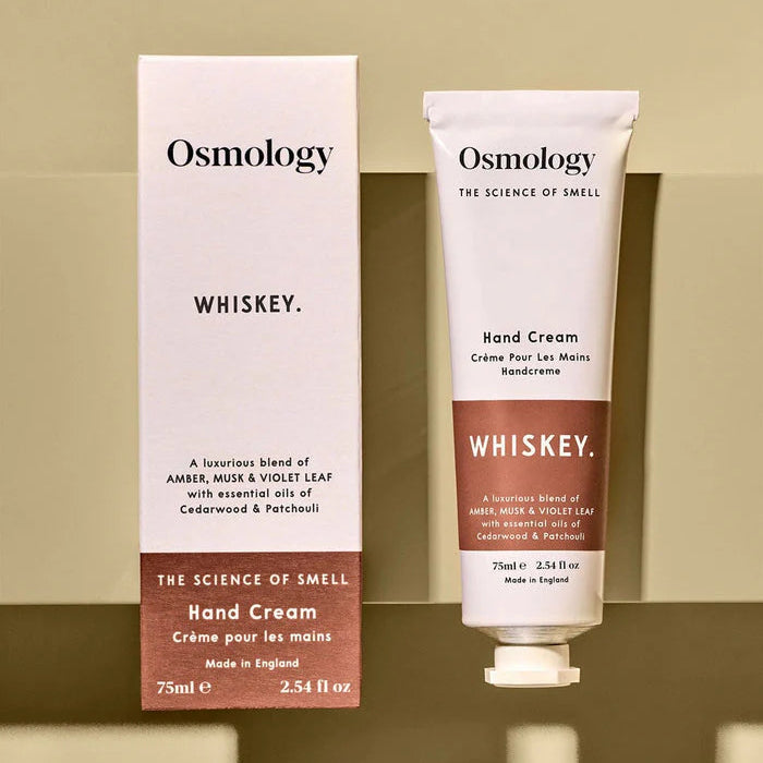 Osmology Whiskey hand cream and packaging on a beige background