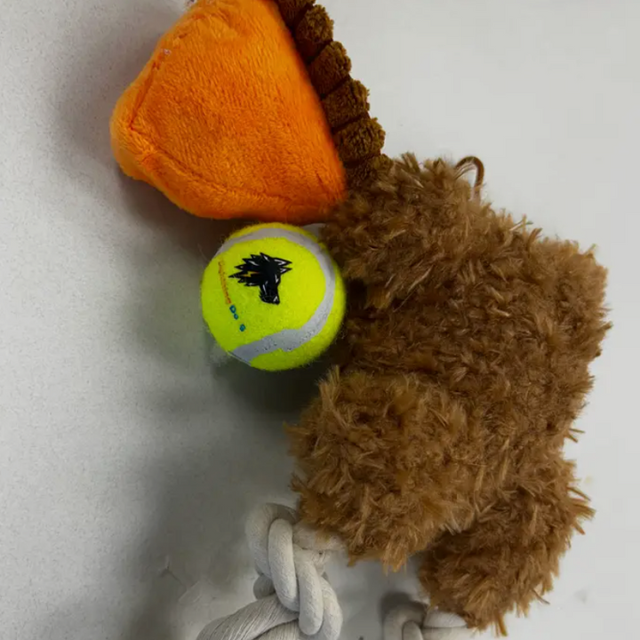 Dog toy with orange heart, tennis ball, and brown plush lion on a white background