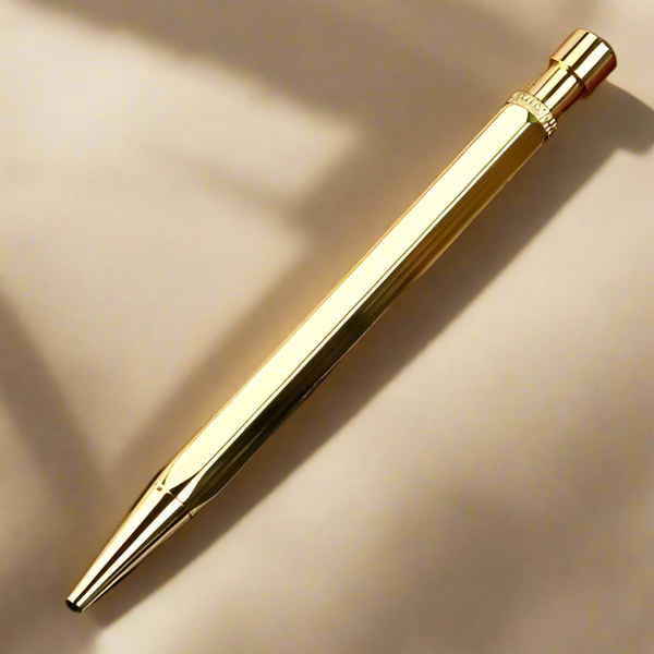 Gold pen on a beige background