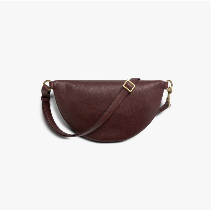 Brown leather saddle bag with a gold buckle on a white background